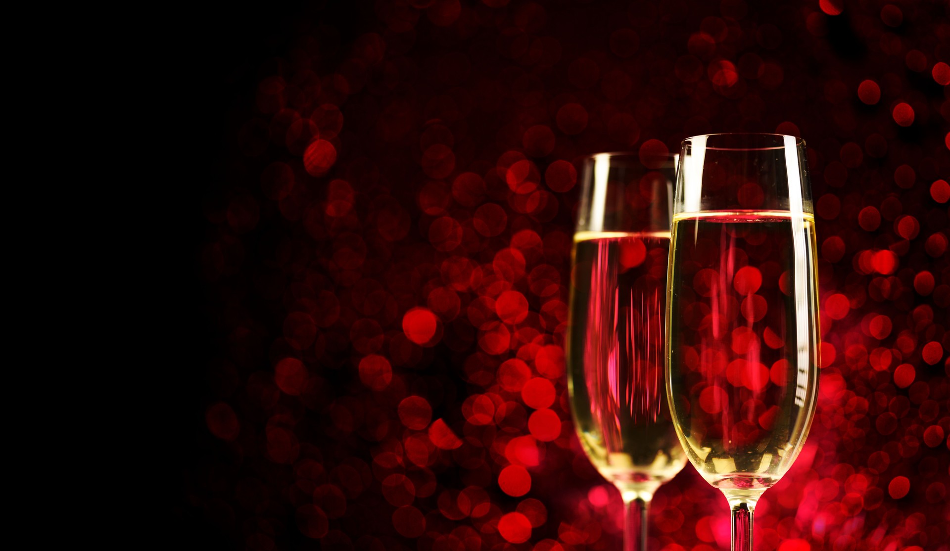 Two champagne glasses on sparkling red bokeh background. Valentine's day dinner, Christmas and new year holiday party.